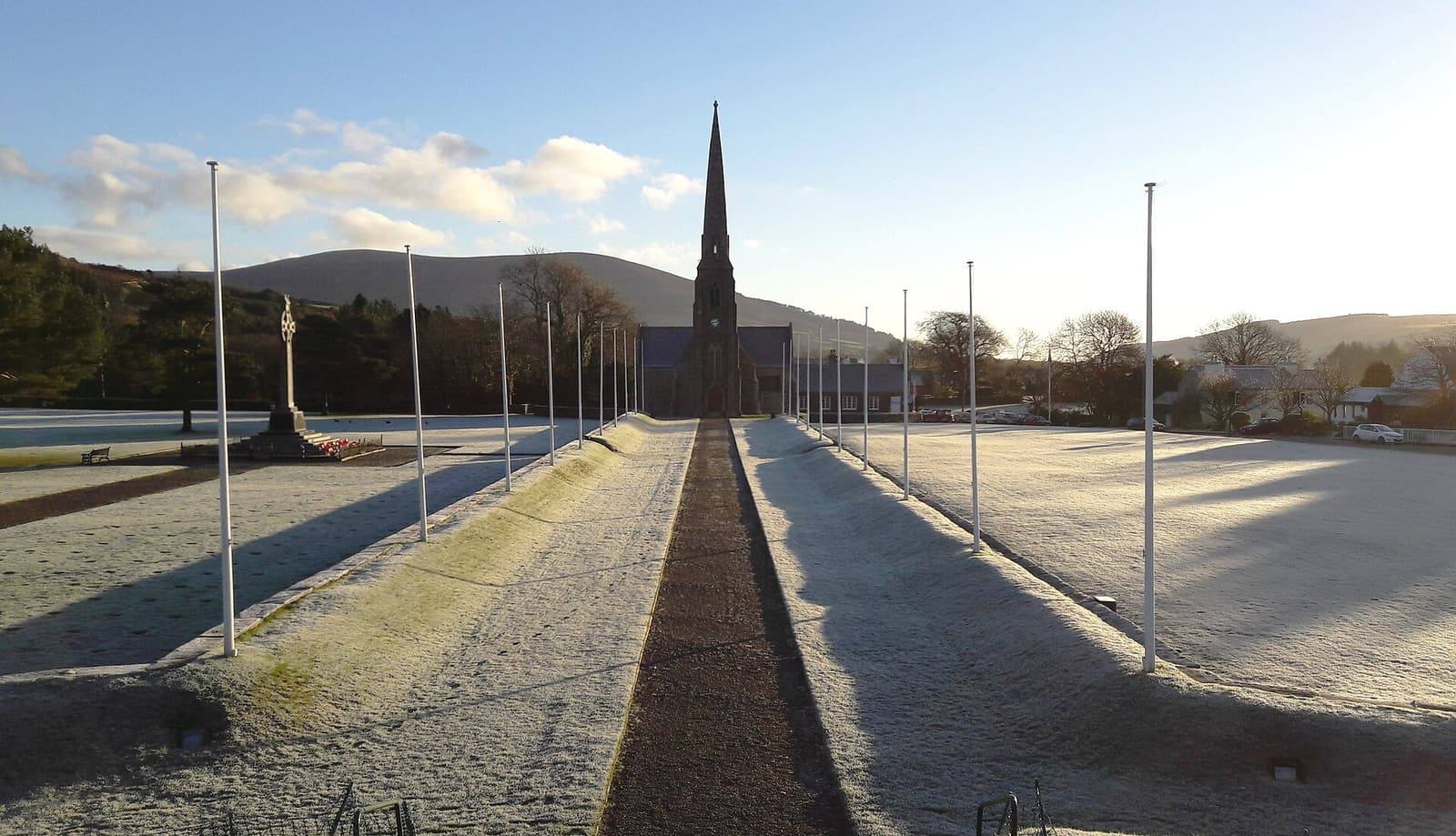 The processional way at St John's white with frost, leading to the Royal Chapel's spire under a pale blue sky.